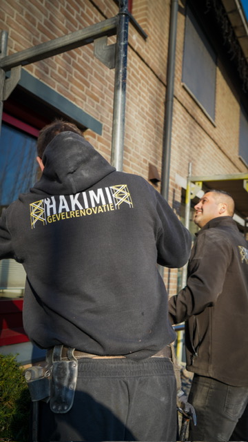 Vakman van Hakimi Gevelrenovatie aan het werk op de steiger