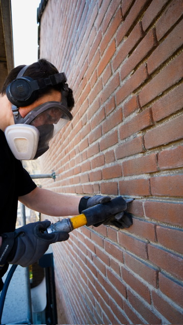 Vakman van Hakimi Gevelrenovatie aan het werk met voegwerk in Breda